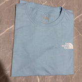 Camiseta Grife The North Face Azul Claro com Logotipo Box Branco